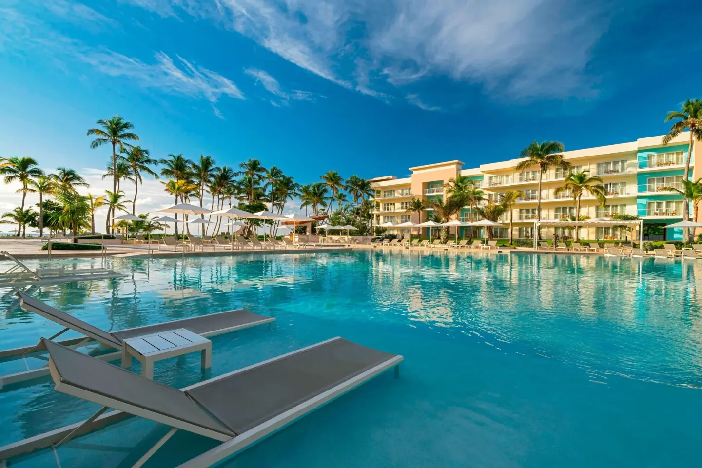 Large outdoor pool with loungers and resort buildings at The Westin Puntacana Resort.
