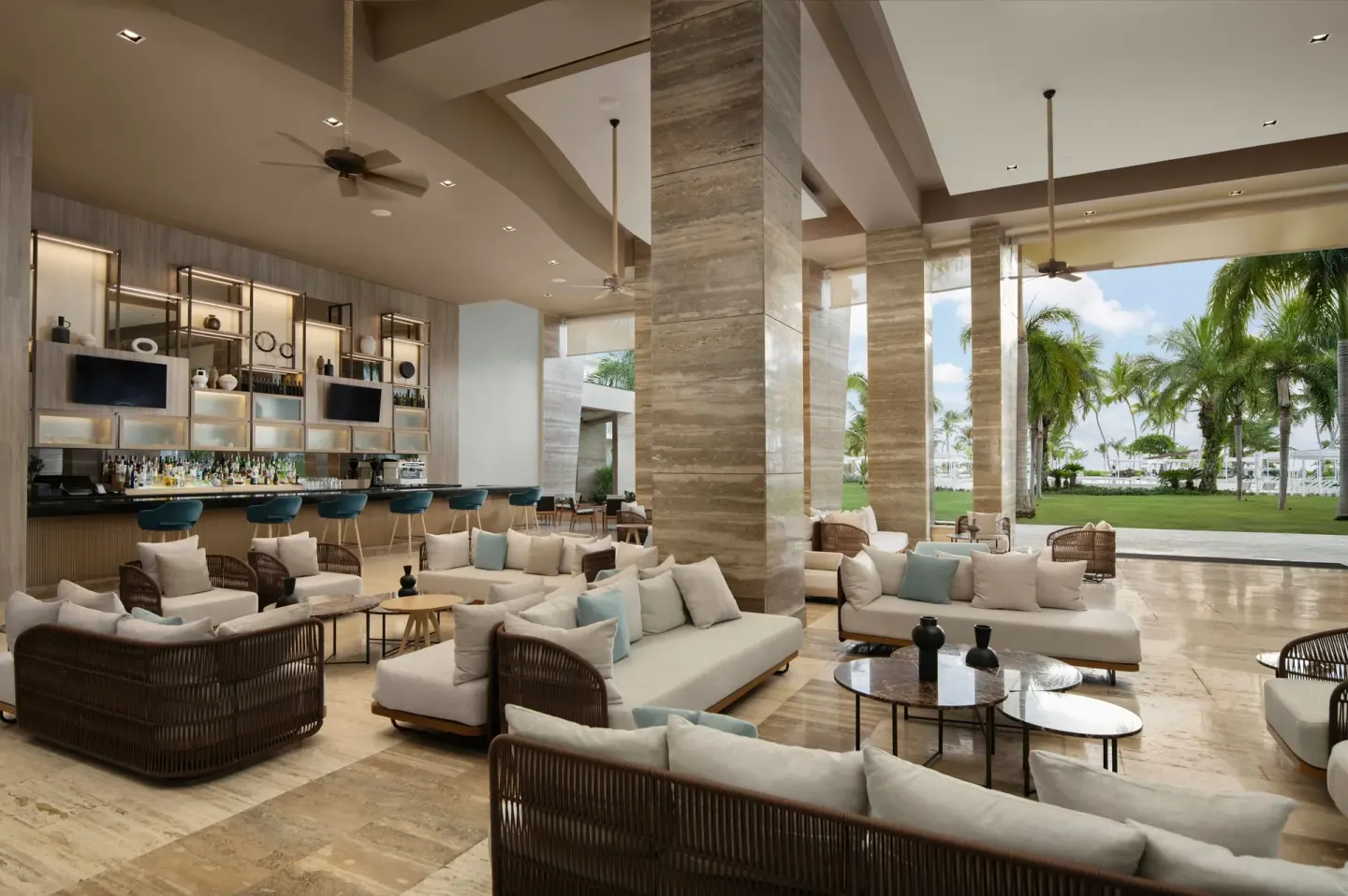 Lobby lounge at The Westin Puntacana Resort with sofas, columns, bar area and palm views.