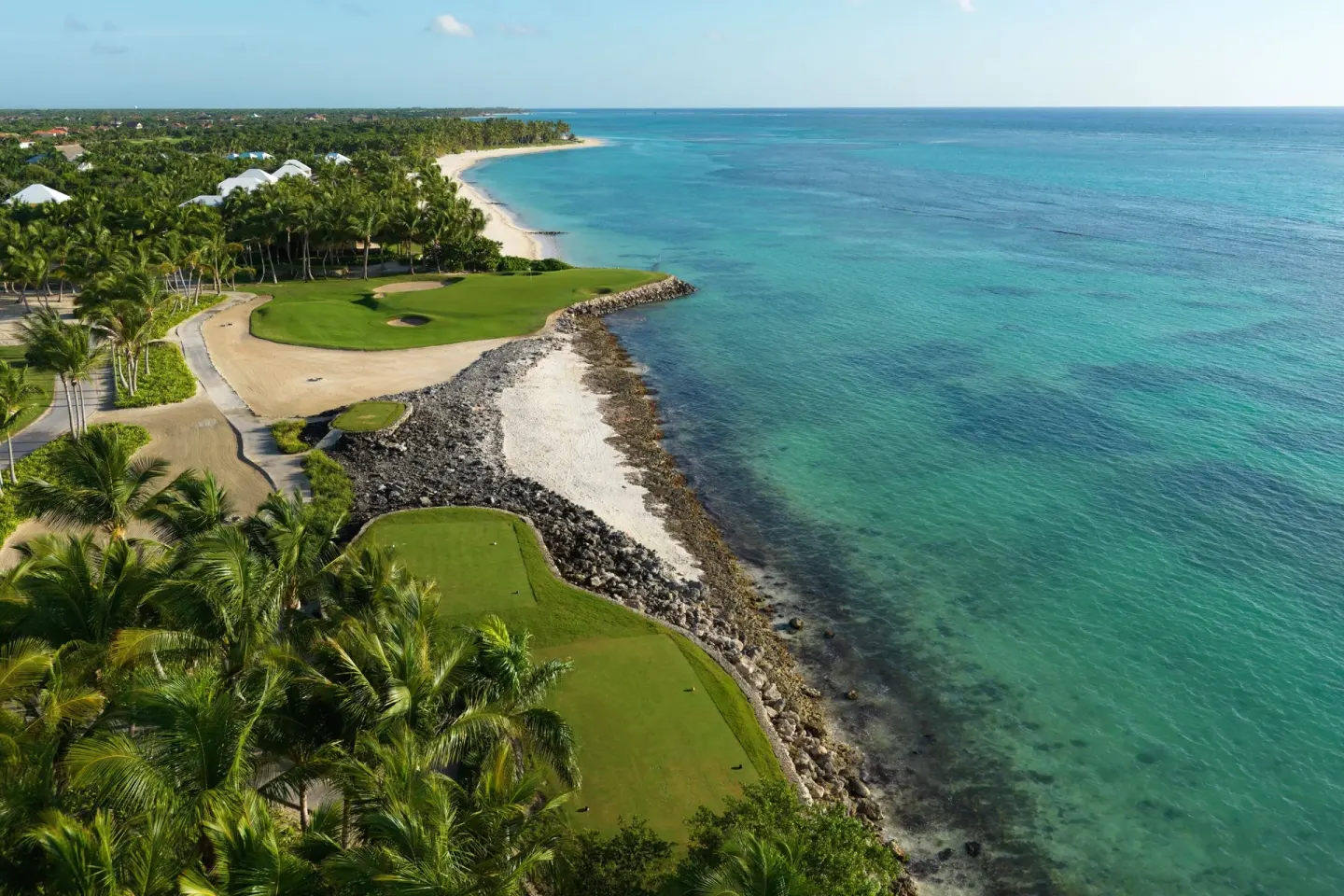 Aerial view of oceanfront golf greens and turquoise water at The Westin Puntacana Resort.