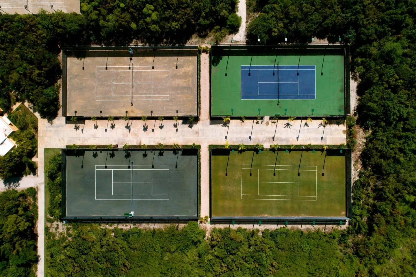 Overhead view of four tennis courts surrounded by trees at The Westin Puntacana Resort.