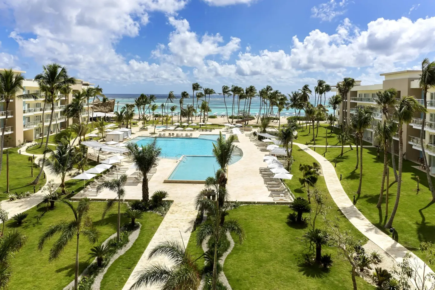 Pool courtyard, palms, and ocean view at The Westin Puntacana Resort.