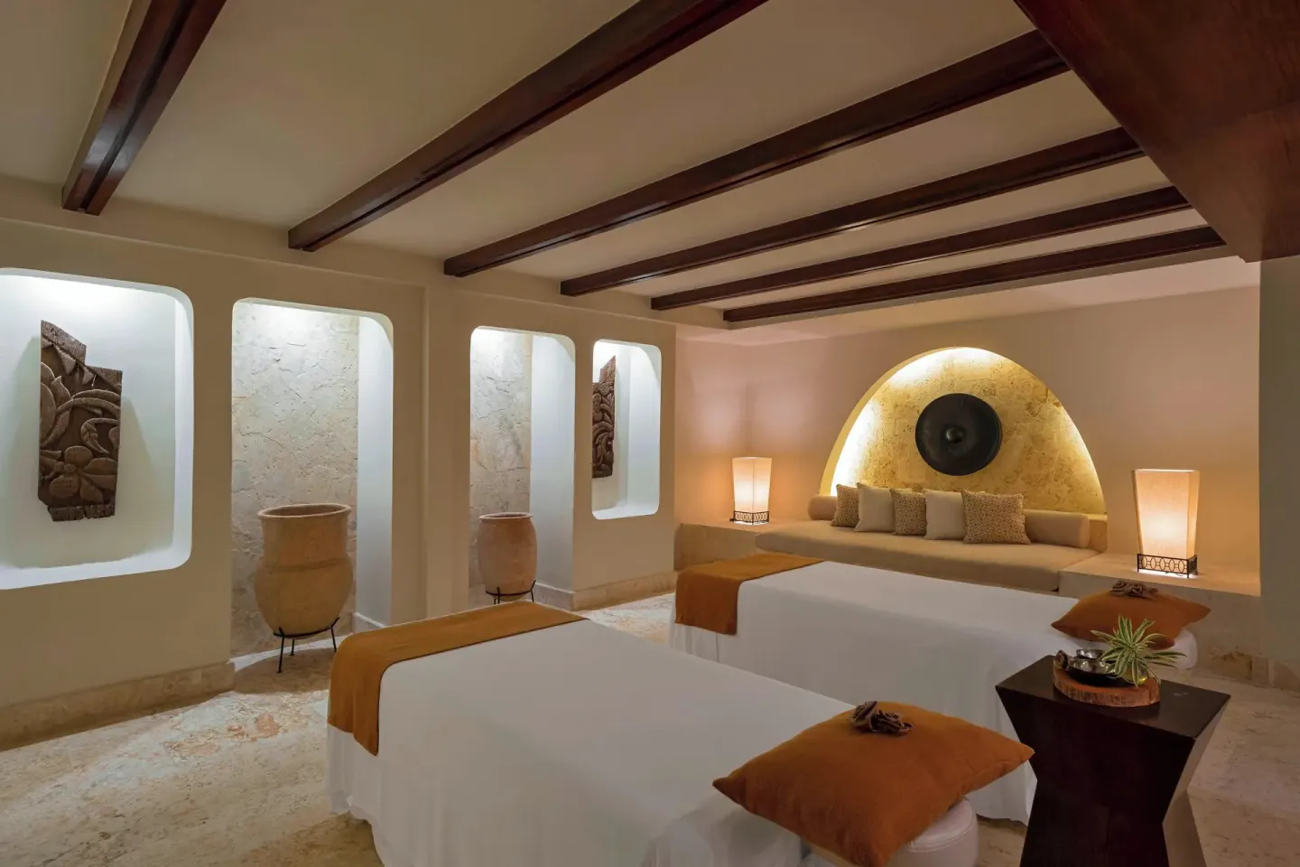 Spa treatment room with two massage tables and arched wall alcove at The Westin Puntacana Resort.