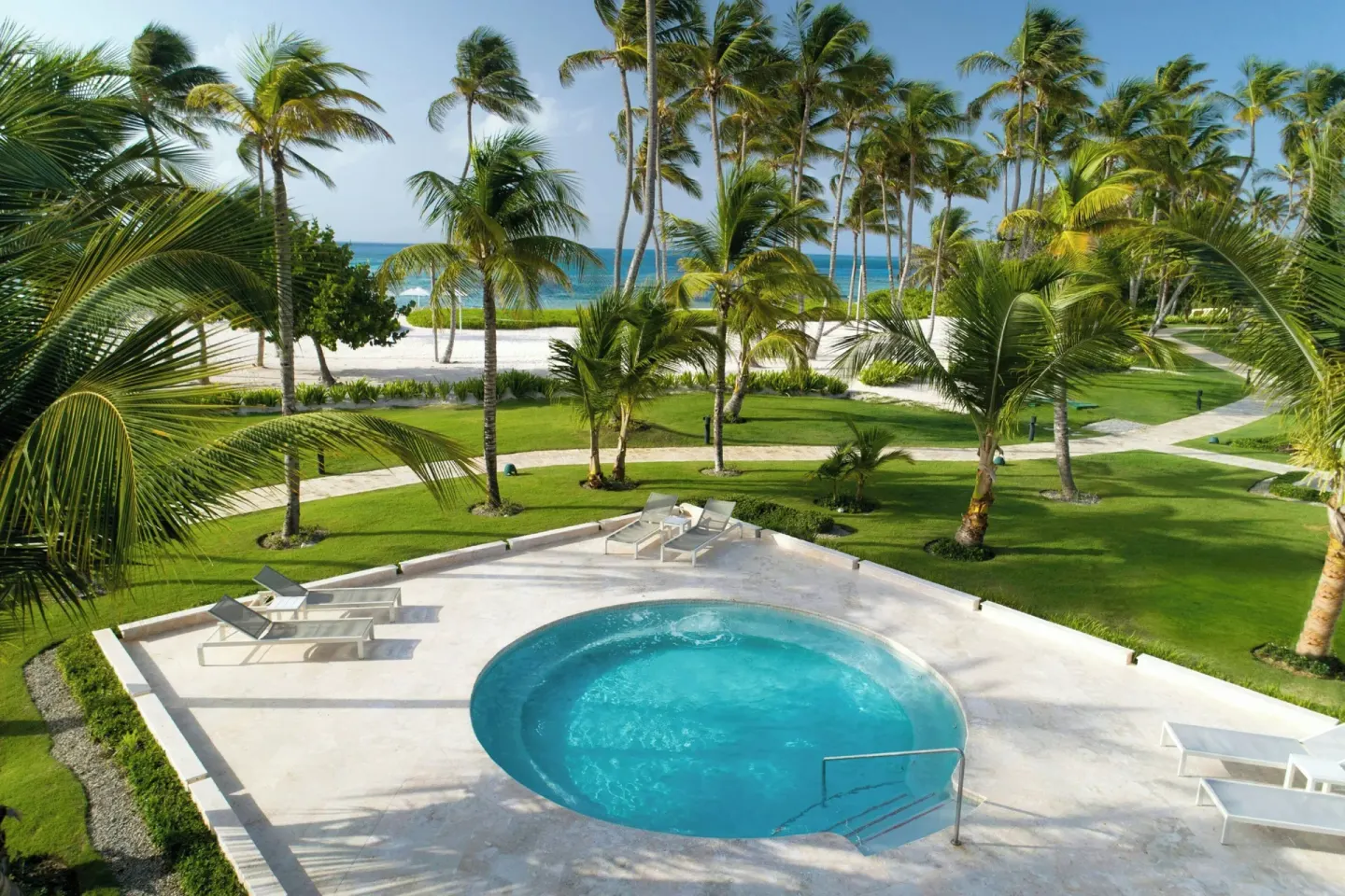 Circular whirlpool terrace overlooking palms, lawn, and beach at The Westin Puntacana Resort.