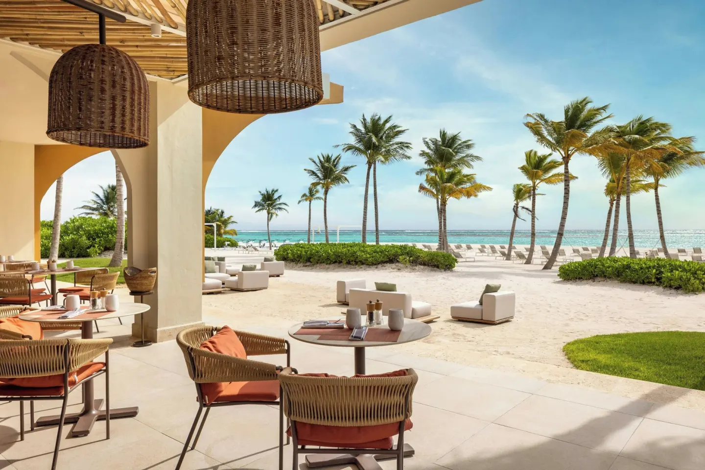 Beachfront terrace seating with palm and ocean views at The Westin Puntacana Resort.