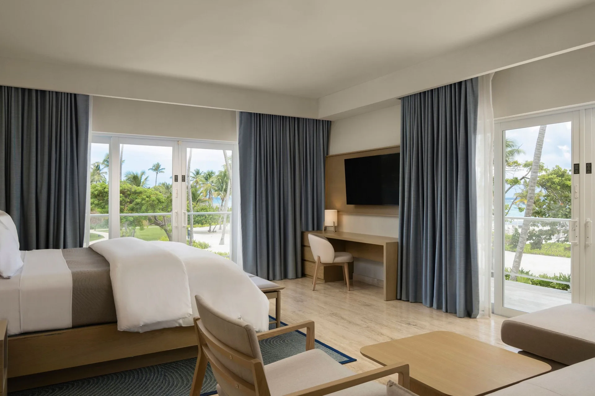 Junior Suite king bedroom with balcony doors at The Westin Puntacana Resort.