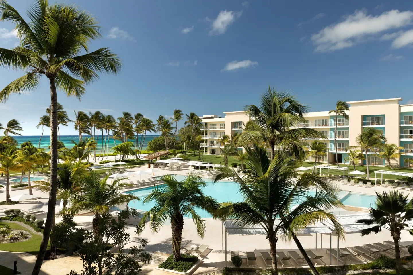 Ocean-view balcony scene with pools, palms, and resort buildings at The Westin Puntacana Resort.