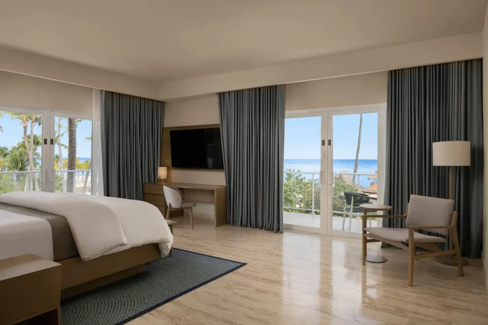 One-bedroom suite king bed with ocean-facing balcony at The Westin Puntacana Resort.