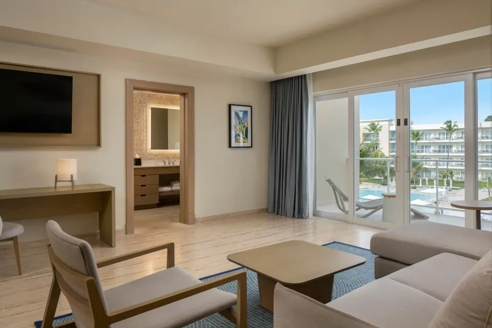 One-bedroom suite living area with balcony and bathroom doorway at The Westin Puntacana Resort.