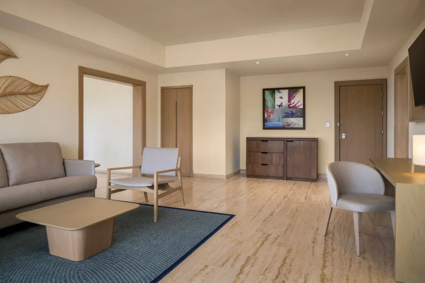 One-bedroom suite sitting area with sofa, desk, and entry door at The Westin Puntacana Resort.