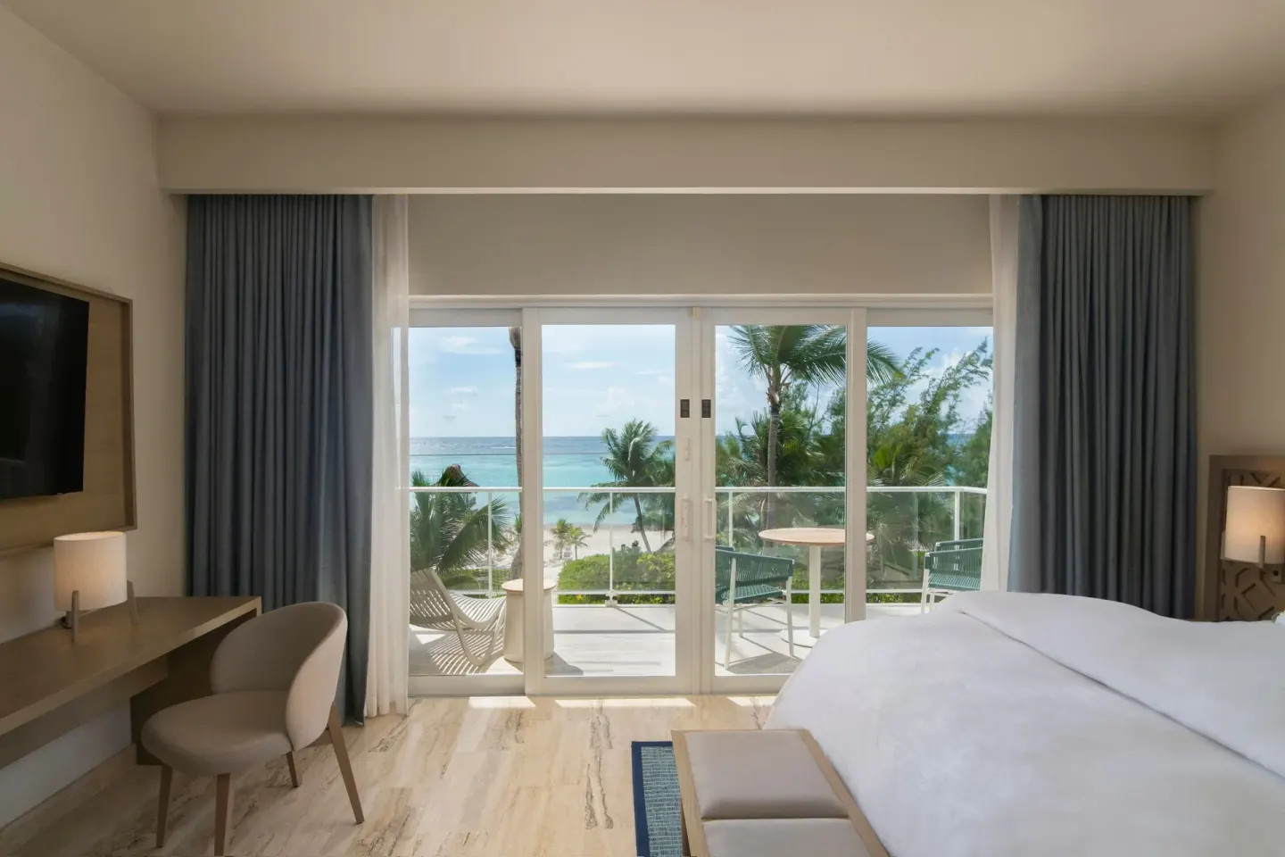 Ocean-view suite bedroom at The Westin Puntacana Resort with king bed, desk, and balcony doors.