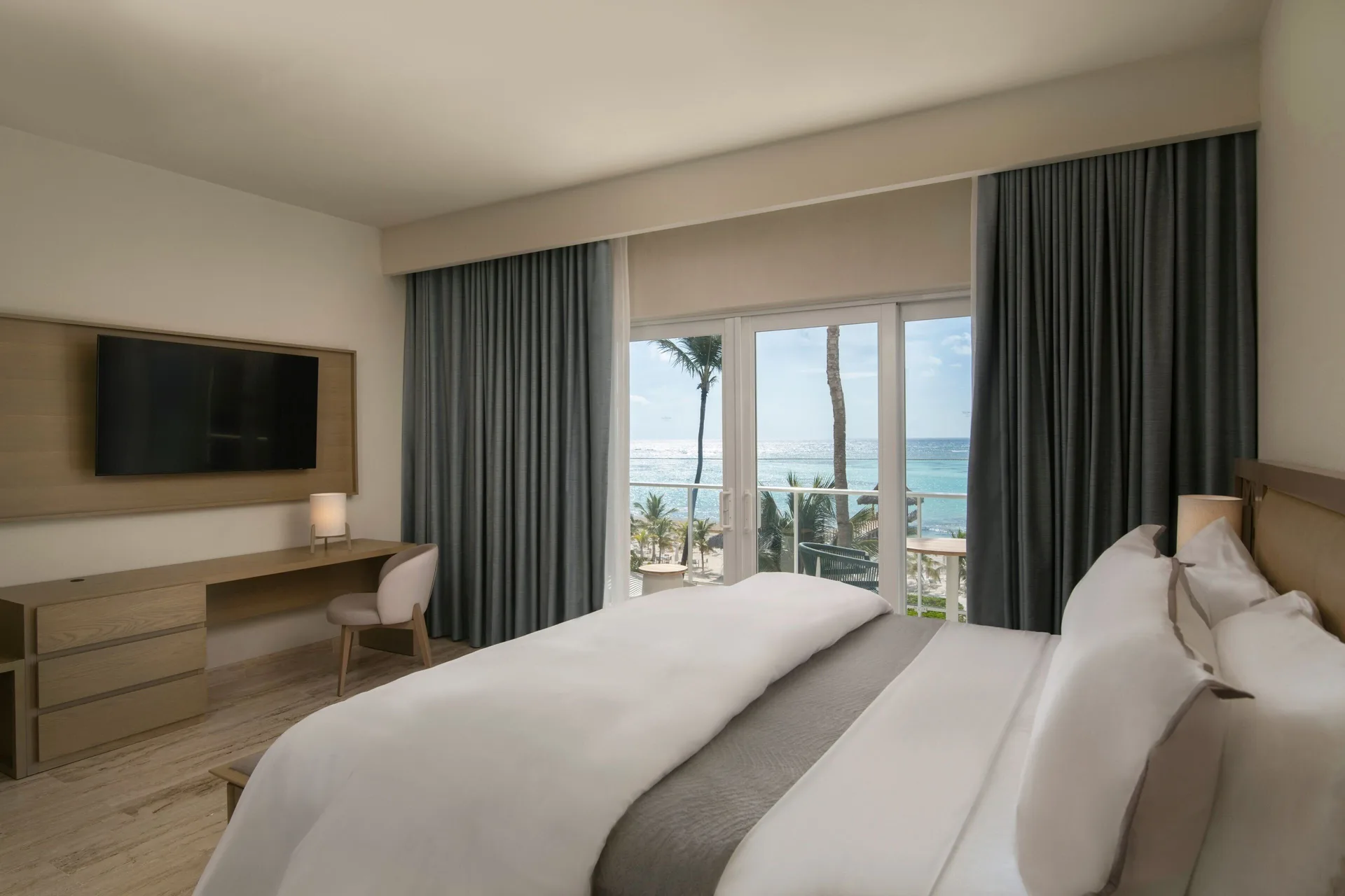 King bed suite bedroom at The Westin Puntacana Resort facing balcony doors and ocean beyond.