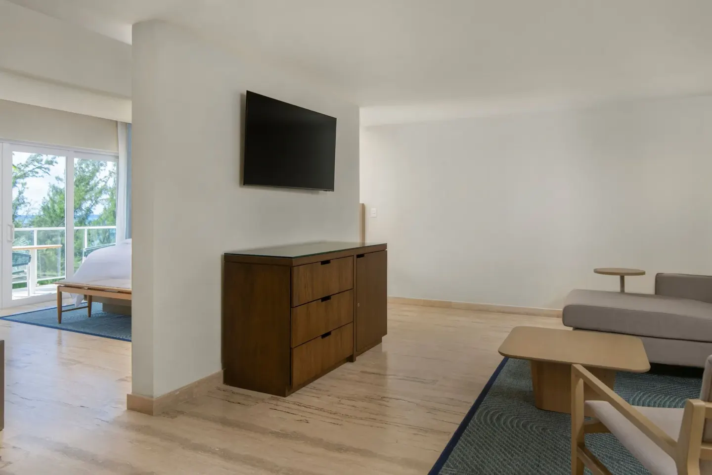 Suite living area at The Westin Puntacana Resort with sofa, TV console, and bedroom visible beyond.