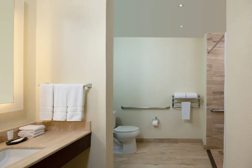 Traditional Room Ocean View bathroom with vanity, toilet, shower, and towels at The Westin Puntacana Resort.