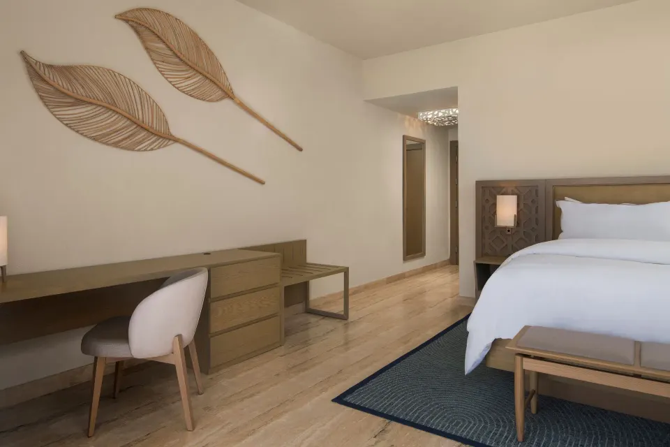 Traditional Room king bed with desk and leaf wall decor at The Westin Puntacana Resort.
