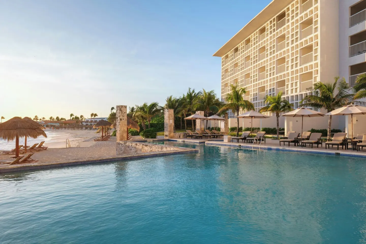Beachfront pool, loungers and resort tower at The Westin Resort & Spa, Cancun.