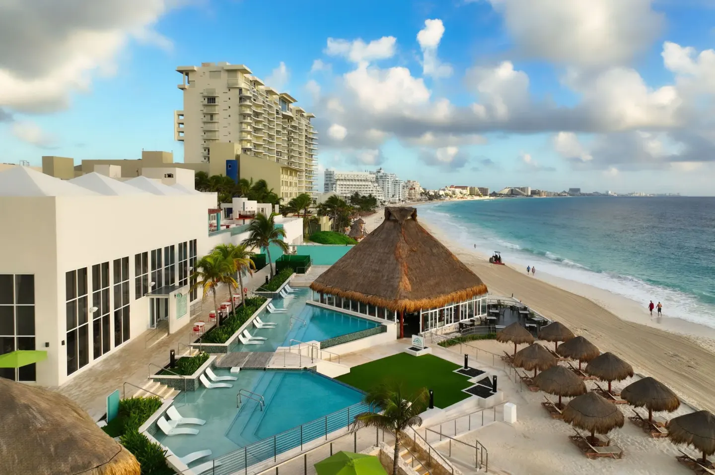 Beachfront pools, palapa roof, and ocean shoreline at The Westin Resort & Spa, Cancun.