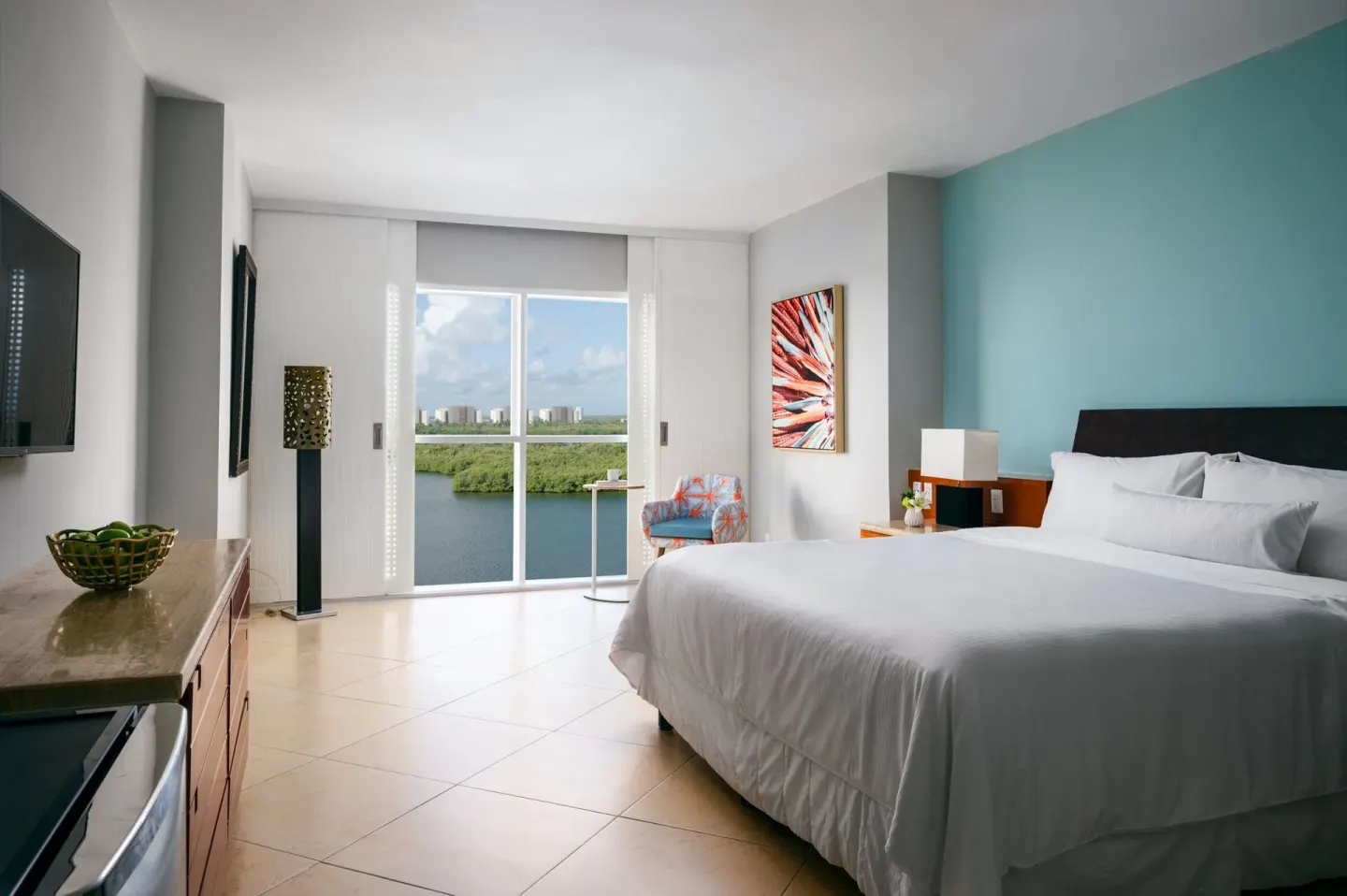 Guest room with king bed and lagoon window view at The Westin Resort & Spa, Cancun.