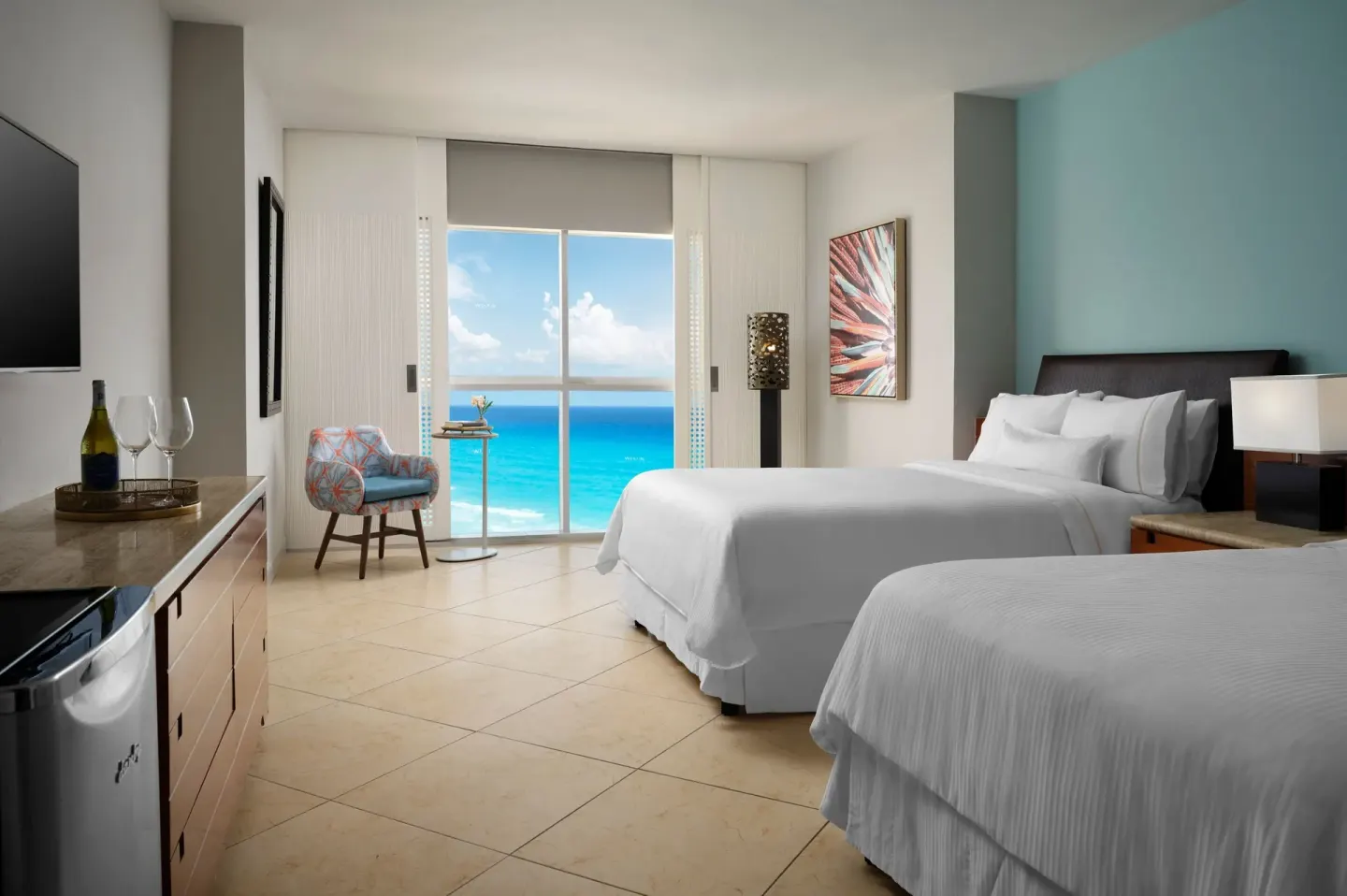 Guest room with two beds, seating, and ocean view at The Westin Resort & Spa, Cancun.