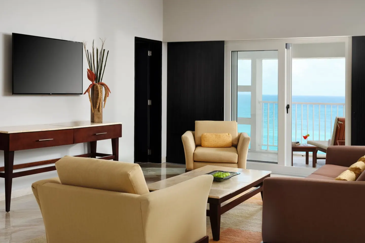 Living room with TV and balcony ocean view at The Westin Resort & Spa, Cancun.