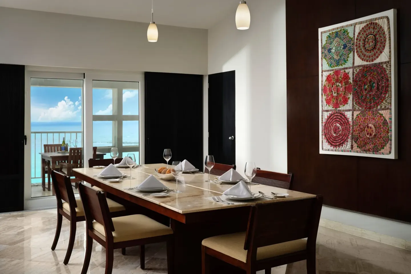 Suite dining table set by an ocean-view balcony at The Westin Resort & Spa, Cancun.
