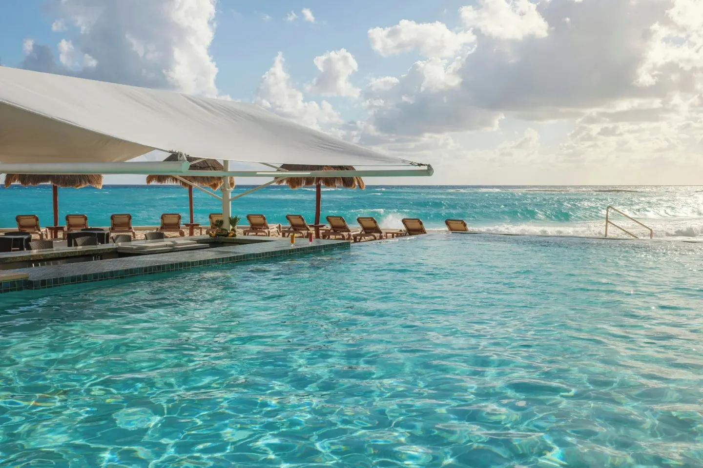 Oceanfront pool with loungers and white shade canopy at The Westin Resort & Spa, Cancun.