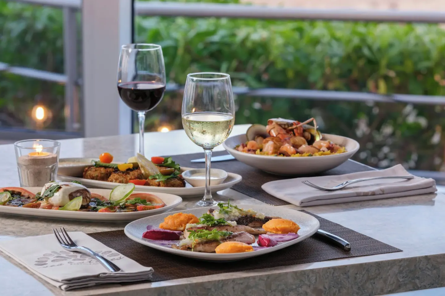 Plated seafood dishes and wine glasses on a dining table at The Westin Resort & Spa, Cancun.