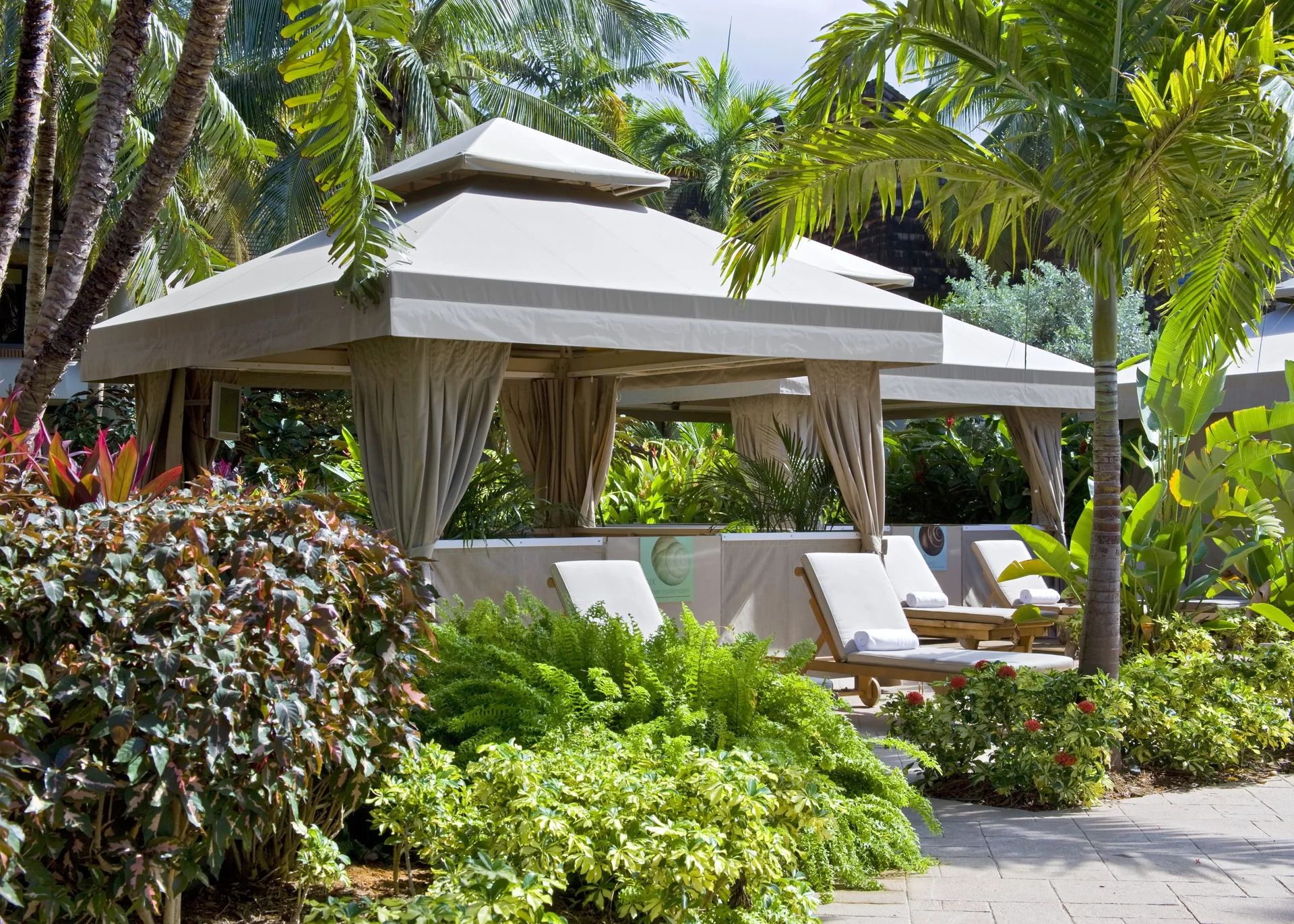 Poolside cabanas with lounge chairs in tropical gardens at The Westin St. John Resort Villas.