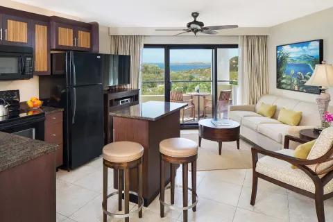 Villa living area with kitchenette, balcony, and bay view at The Westin St. John Resort Villas.
