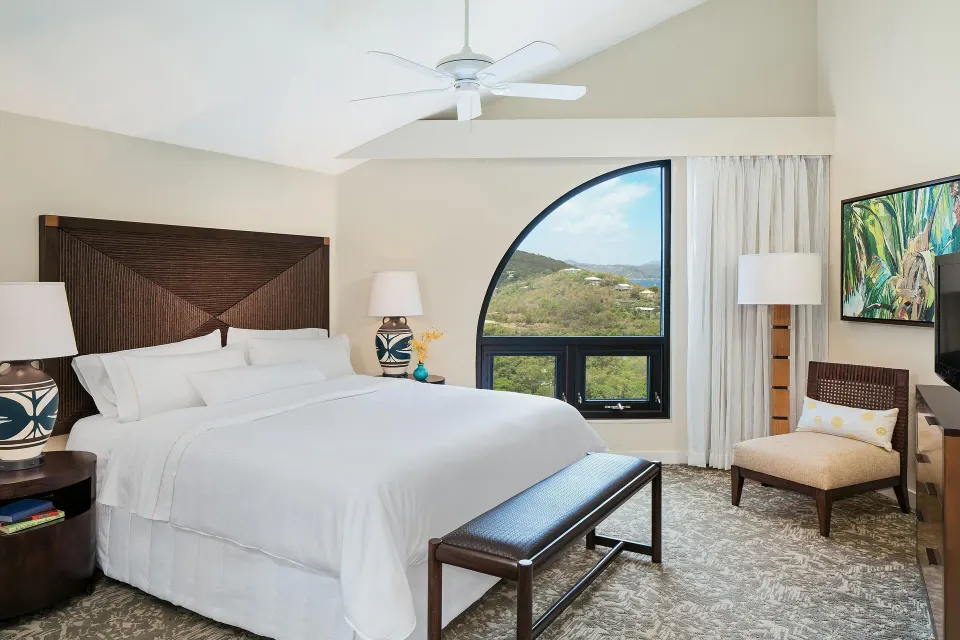 King bedroom with resort-view window and seating at The Westin St. John Resort Villas.