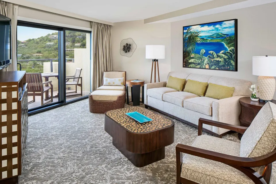 Living room with sofa, chairs, balcony doors, and hillside view at The Westin St. John Resort Villas.