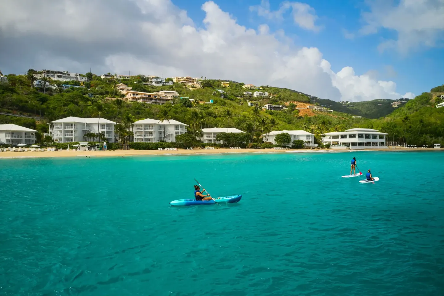 Kayakers and paddleboarders move across the bay at The Westin St. Thomas Beach Resort & Spa.