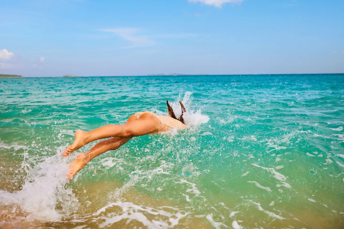 Swimmer diving into turquoise water near The Westin St. Thomas Beach Resort & Spa.