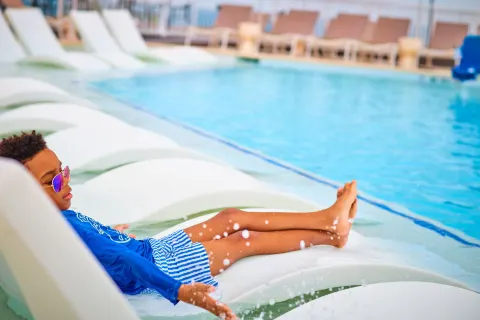 Child reclining on an in-water pool lounger at The Westin St. Thomas Beach Resort & Spa.