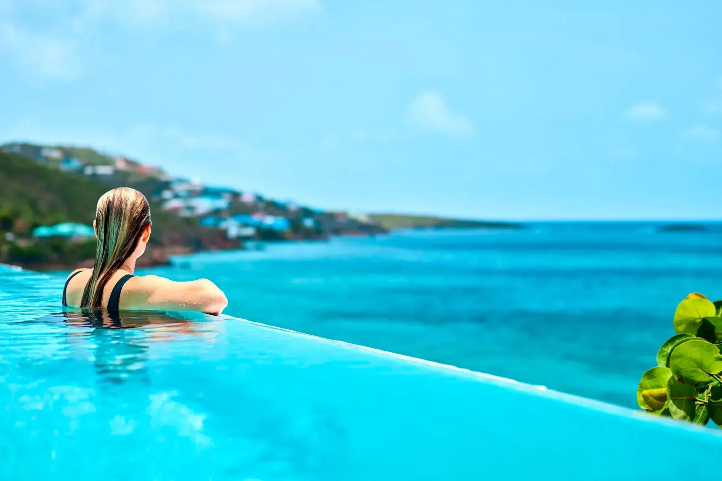 Guest looking over turquoise water from the pool at The Westin St. Thomas Beach Resort & Spa.