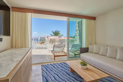 Living room with terrace and ocean glimpse at The Westin St. Thomas Beach Resort & Spa.
