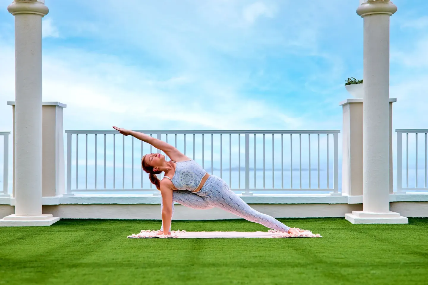 Yoga pose on an oceanfront lawn at The Westin St. Thomas Beach Resort & Spa.