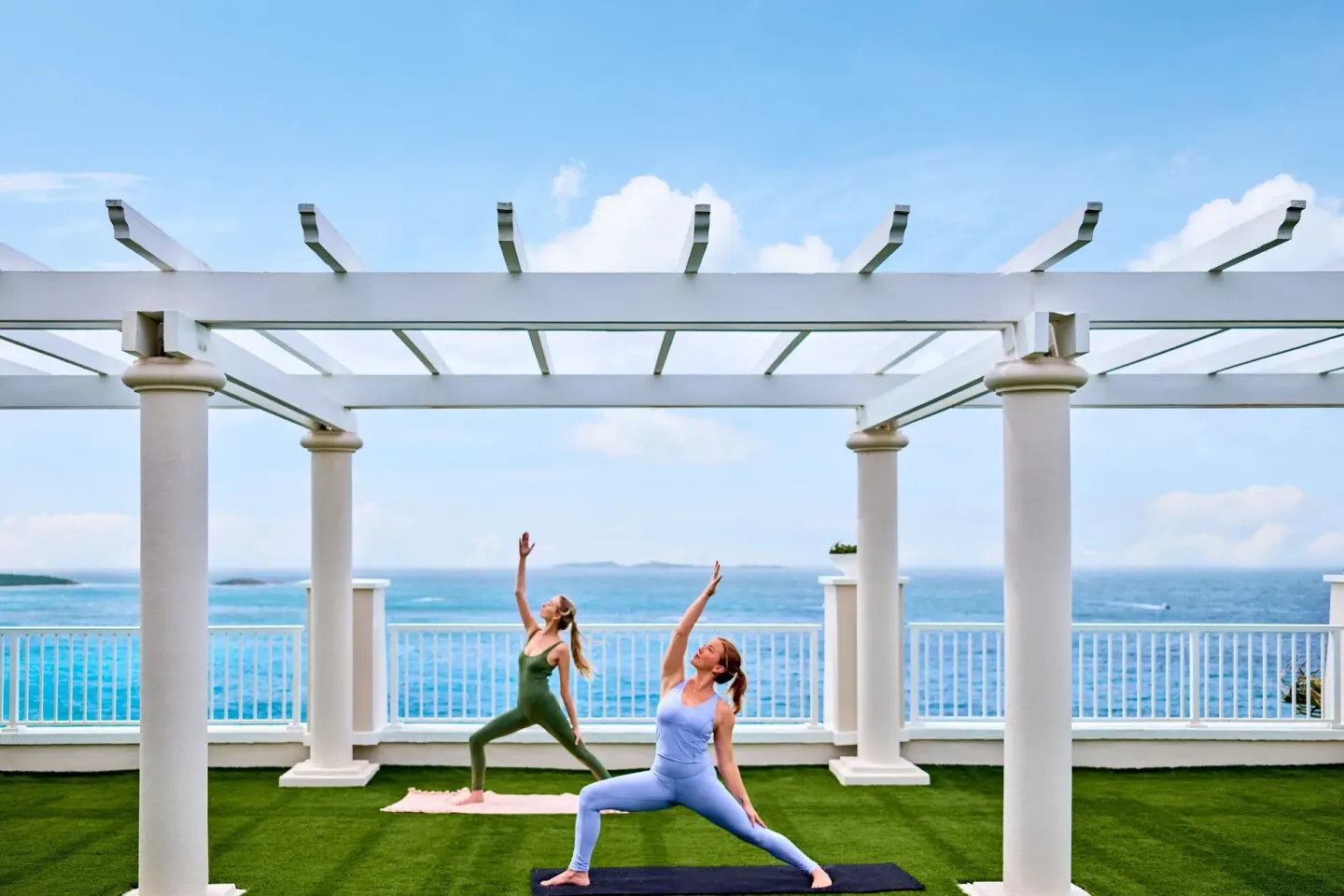 Outdoor yoga under a white pergola at The Westin St. Thomas Beach Resort & Spa.