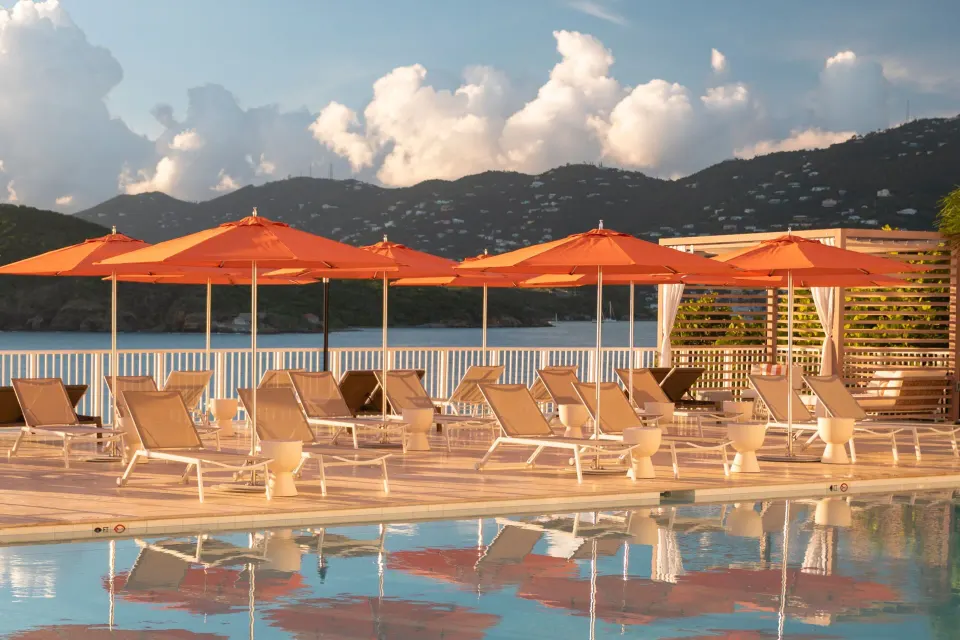 Pool deck loungers and orange umbrellas at The Westin St. Thomas Beach Resort & Spa.