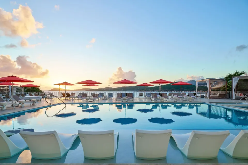Sunset pool deck with red umbrellas at The Westin St. Thomas Beach Resort & Spa.