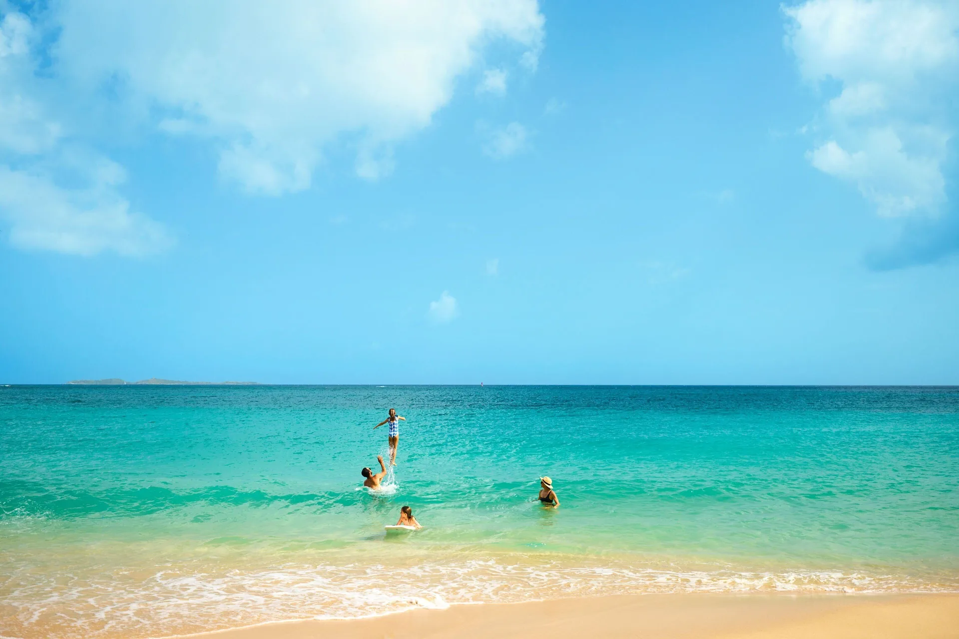 People swimming in turquoise ocean water at The Westin St. Thomas Beach Resort & Spa.