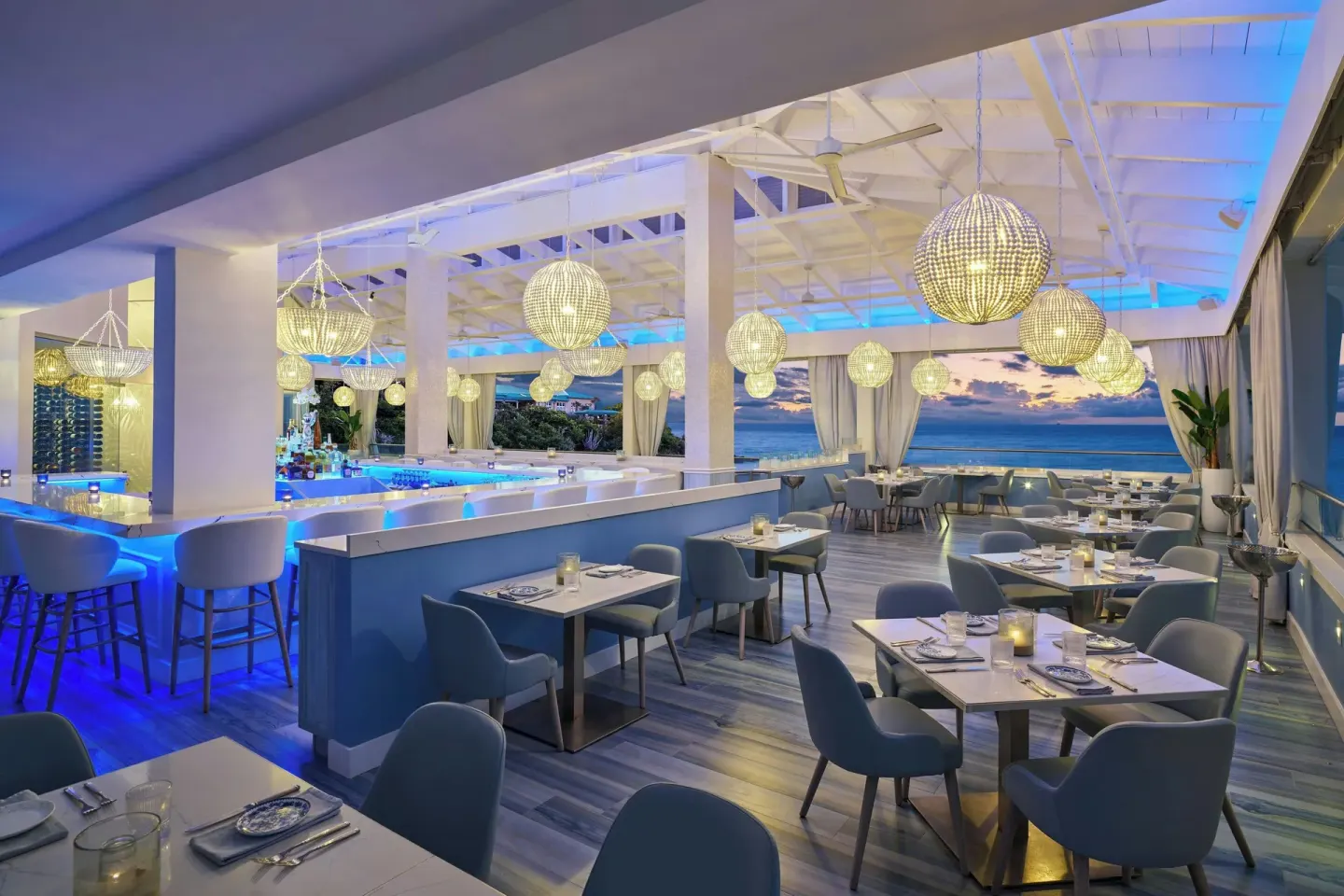 Blue-lit open-air dining room with ocean views at The Westin St. Thomas Beach Resort & Spa.