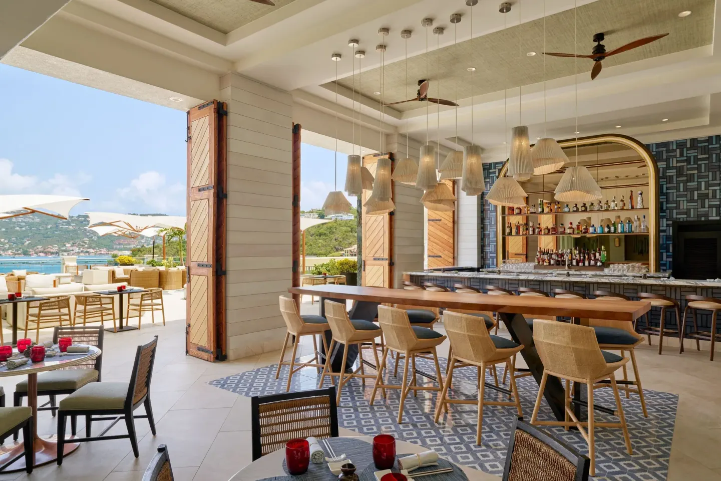 Indoor-outdoor bar and dining area with bay views at The Westin St. Thomas Beach Resort & Spa.