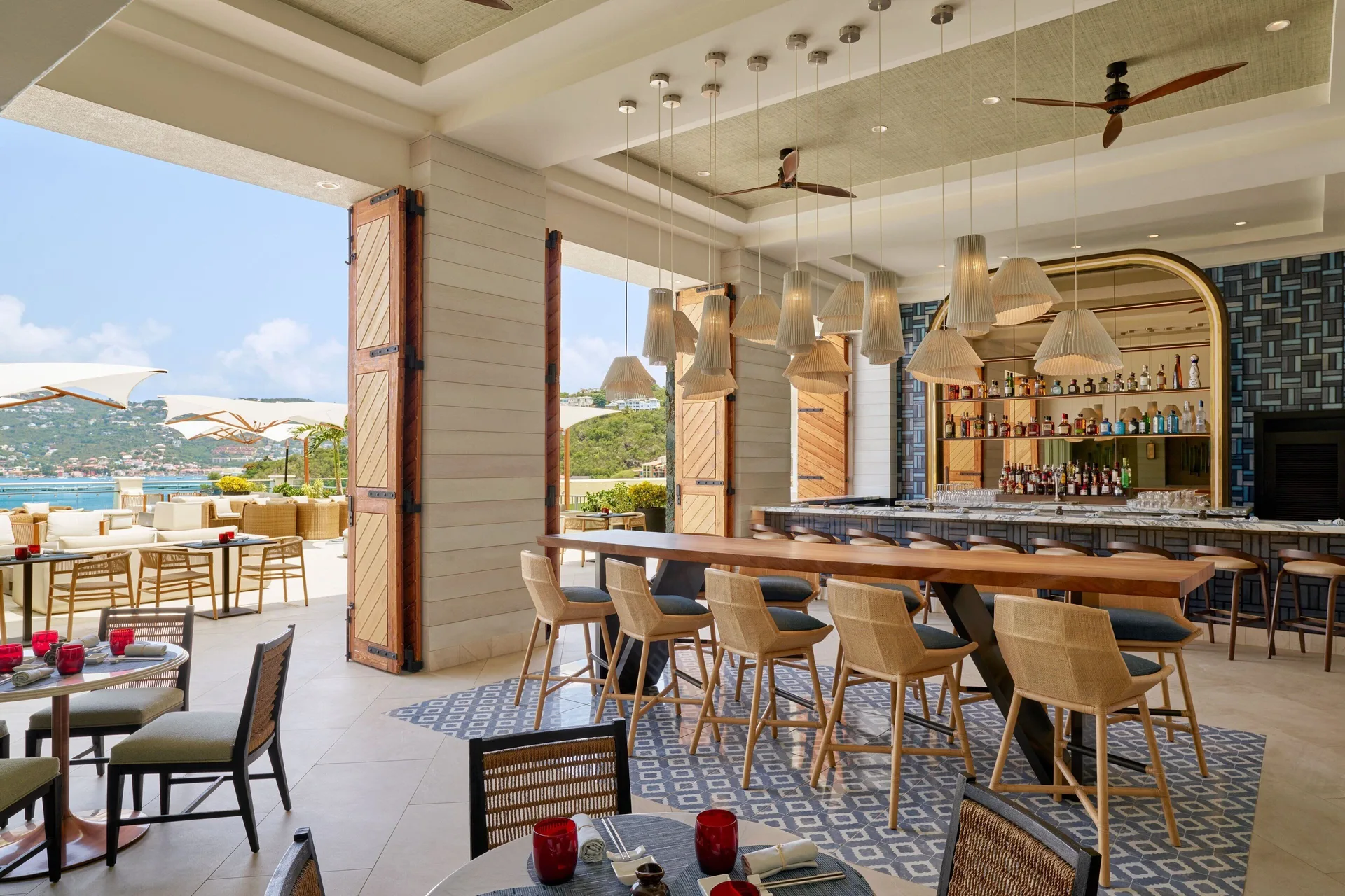 Indoor-outdoor bar and dining area with bay views at The Westin St. Thomas Beach Resort & Spa.