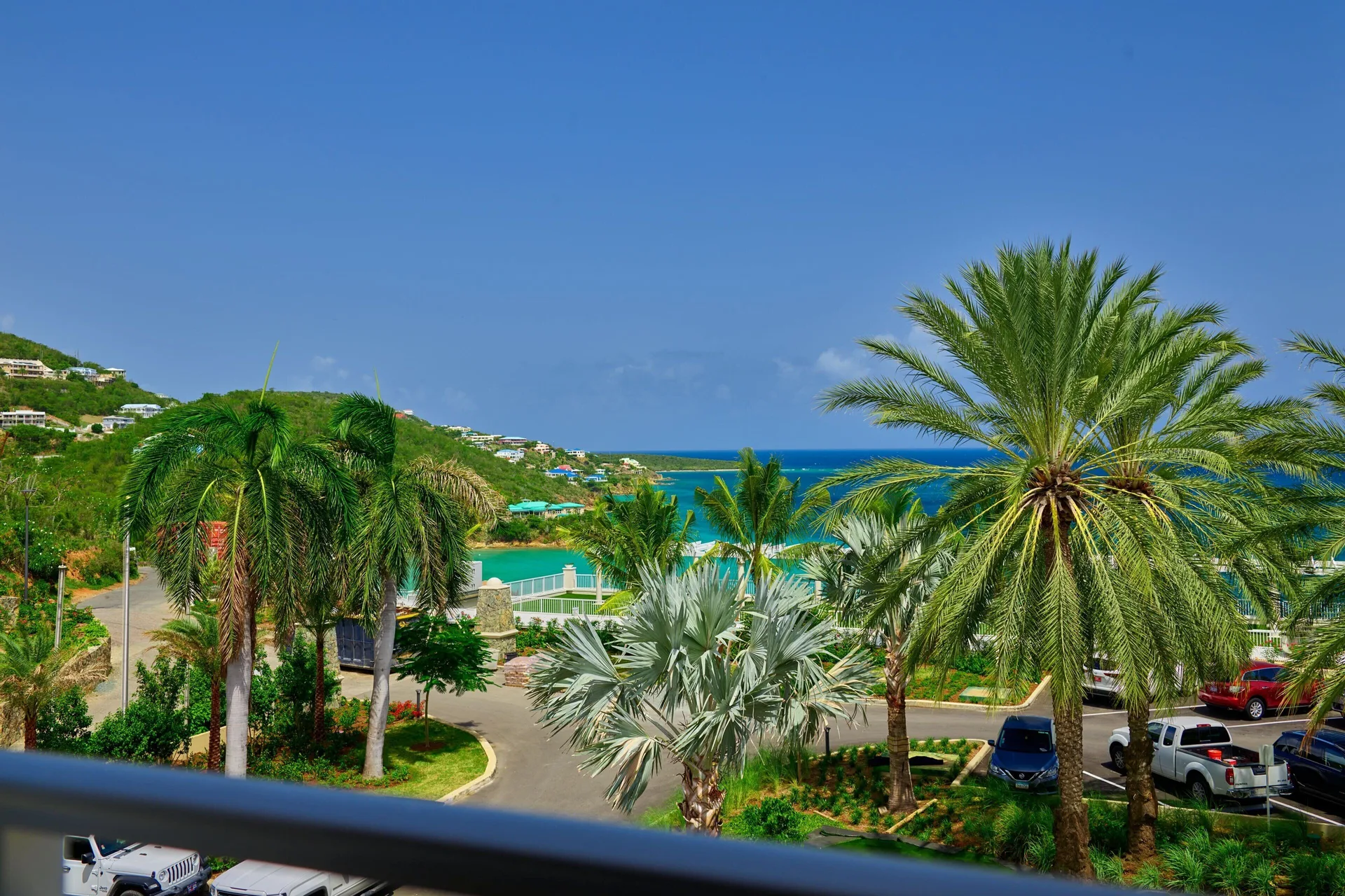 Garden View room balcony overlooks palms and hillside water views at The Westin St. Thomas Beach Resort & Spa.