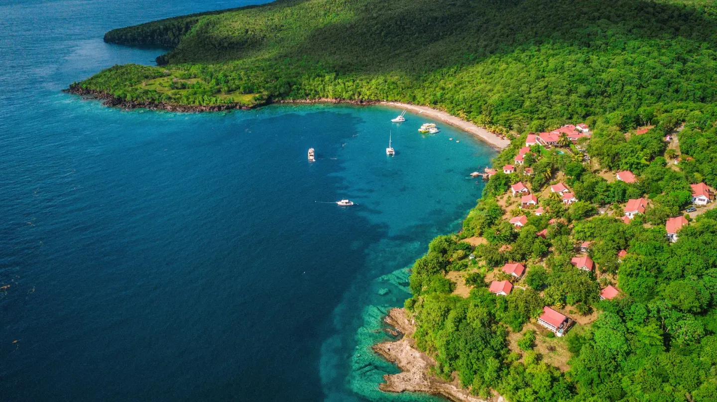 Aerial view of hillside cottages and the bay at Ti Kaye Resort & Spa.