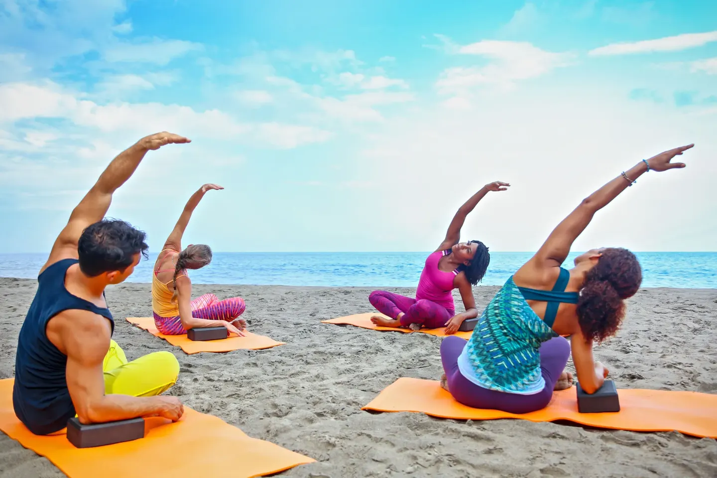 Guests practice yoga on the beach beside the sea at Ti Kaye Resort & Spa.