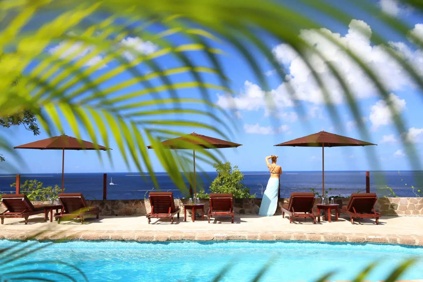 Pool loungers and umbrellas overlook the sea at Ti Kaye Resort & Spa.