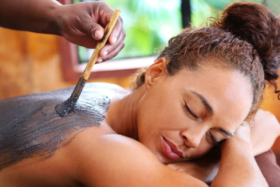 Spa therapist applying a body treatment to a guest at Ti Kaye Resort & Spa.