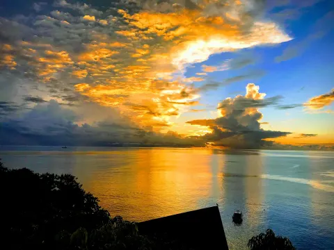 Golden sunset clouds reflected over the sea at Ti Kaye Resort & Spa.