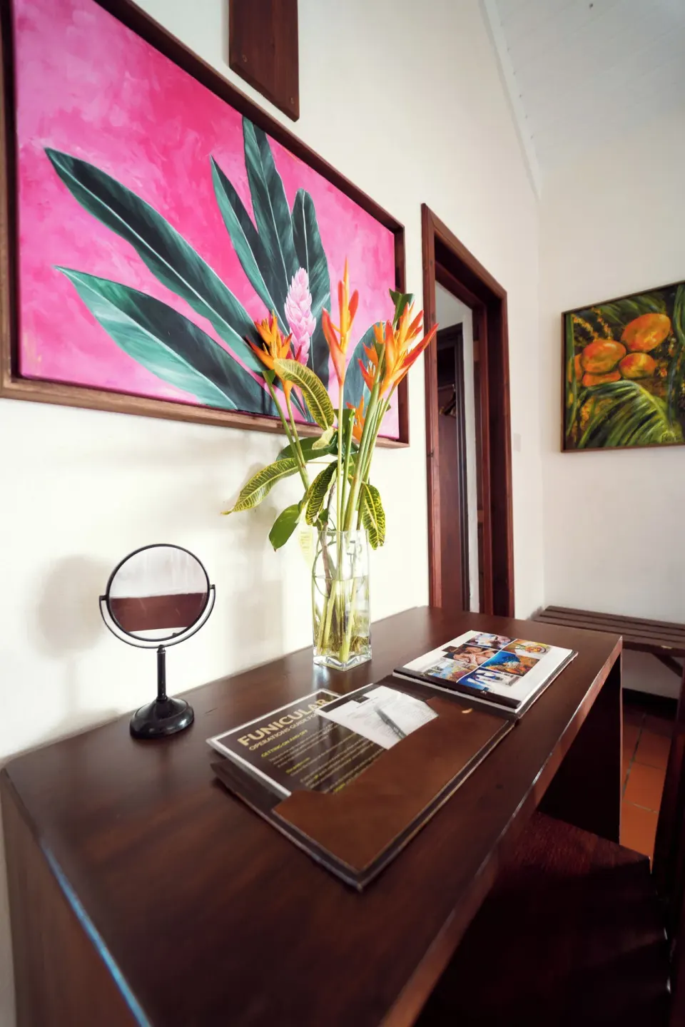 Ocean View Cottage desk with flowers, mirror, and tropical artwork at Ti Kaye Resort & Spa.